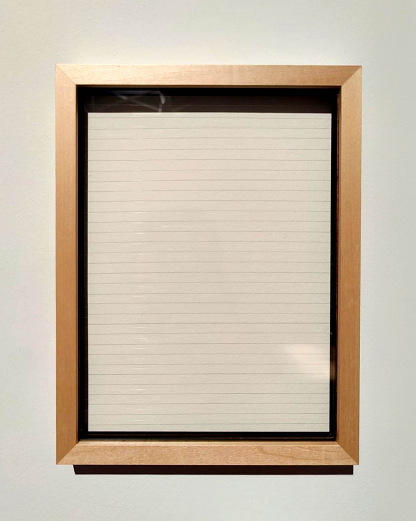 Framed piece of lined paper.