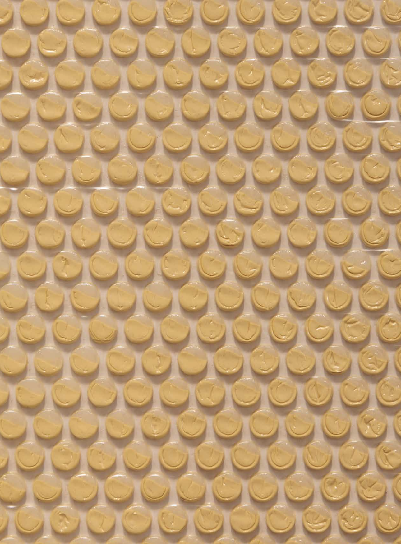Close up of an artwork, a circle made by injecting yellow paint in some of the bubbles of a bubble wrap