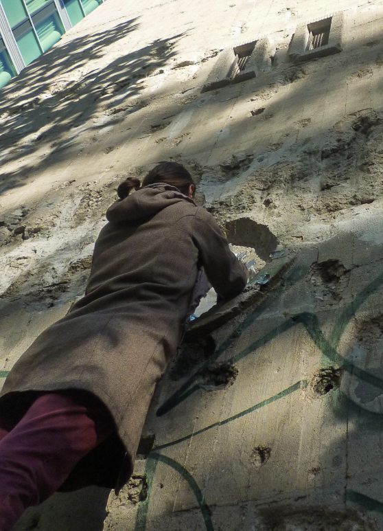 Nadia Kaabi-Linke taking transfer prints rom a damaged wall.