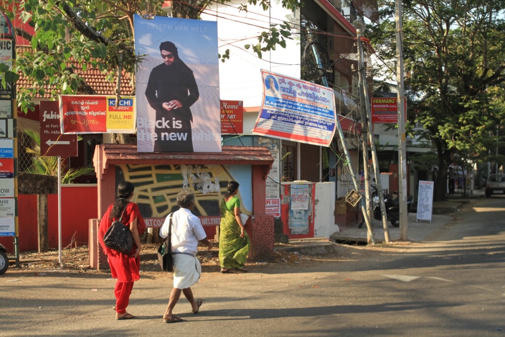 Shot of a road with houses in the background and people walking