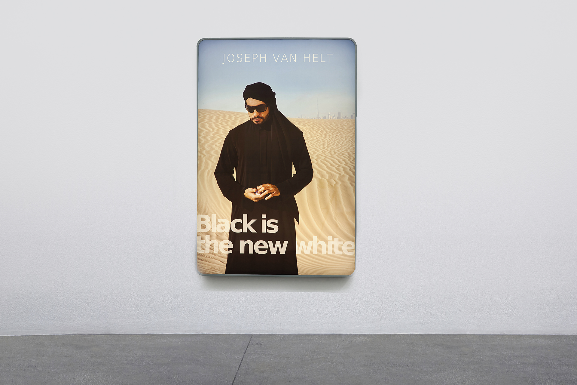 A Photograph printed on a light box of a man standing in the desert.