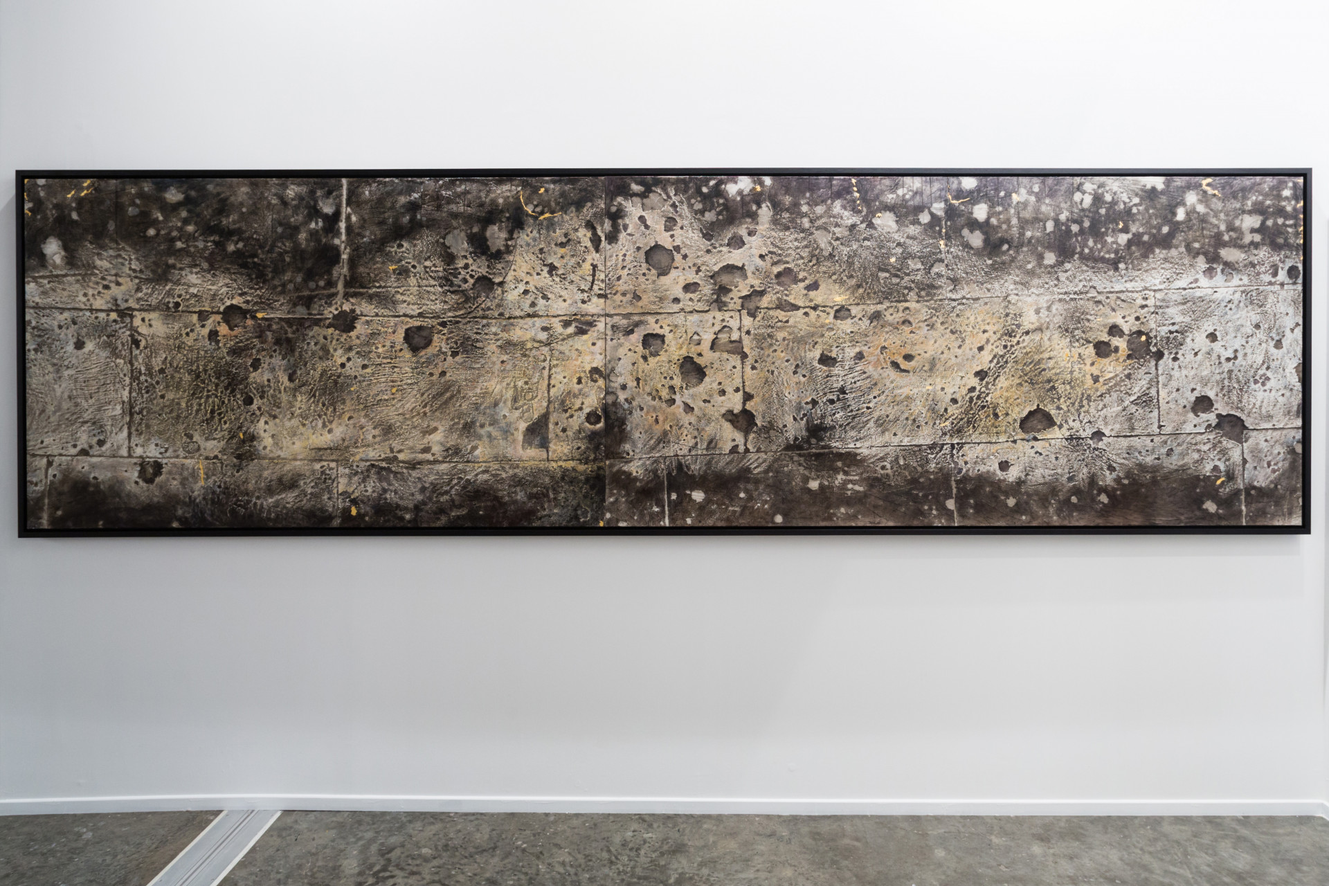 Installation view, off the Wall, 2008, a weathered Berlin façade with bullet-marked ornaments, symbolizing war's remnants and resilience amid change, transferred onto canvas by the artist Nadia Kaabi-Linke