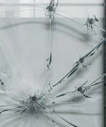 Close up of a sculpture made of Steel, glass, lead, in the form of the main windows of the Tunisian parliament. The glass is broken from multiple bullets. Nadia Kaabi-Linke Lahmi
