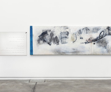 A glass engraved with text, next to a canvas with transferred traced of a wall. Nadia Kaabi-Linke Rue El Azafine