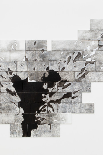 Nadia Kaabi-Linke Phoenix, Isolated installation view of a multiple canvasses painting with transfer prints of a damaged stone wall on a wall.