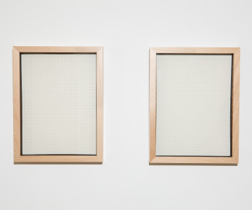 Two object frames showing squares and lines on paper hanging on a wall. Two object frames with paper hanging on a wall in a museum. Nadia Kaabi-Linke, Everything I Always Wanted to Tell You.