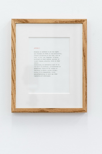 Paperwork with text in a wooden frame.