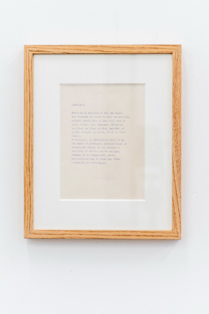 Paperwork with faded text in a wooden frame.