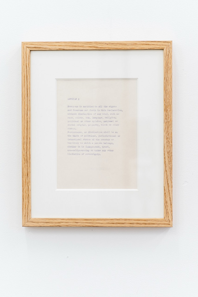 Paperwork with faded text in a wooden frame.