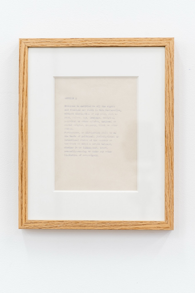 Paperwork with faded text in a wooden frame.