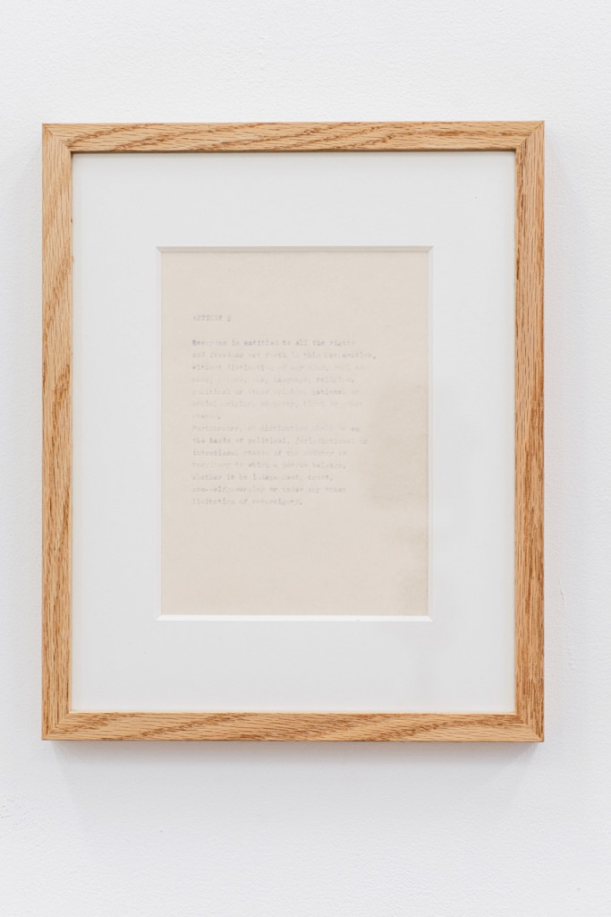 Paperwork with faded text in a wooden frame.