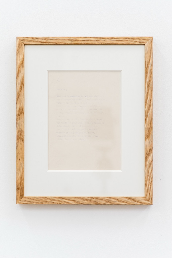 Paperwork with faded text in a wooden frame.