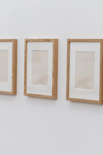A series of eight paperworks with frames.