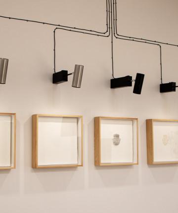 5 framed artworks depicting Fatimas hand in different material. The frames are individually lit by lamps resembling survaillance cameras. Nadia Kaabi-Linke, Fatima.