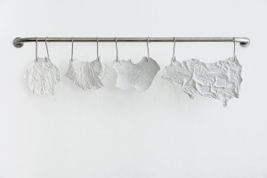 Fragile plaster casts hang like meat at the butcher's on a white wall.