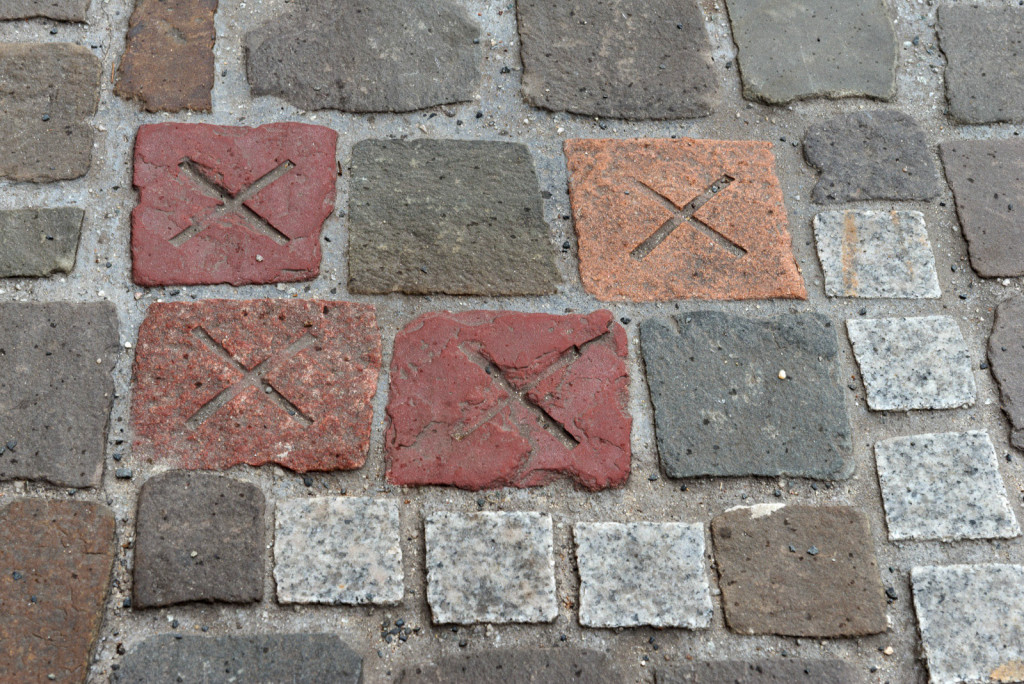 Paving stones in different stones, some have an x marked on the surface.