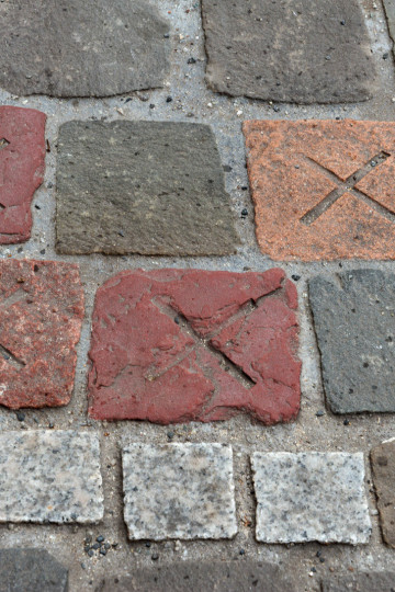 Paving stones in different stones, some have an x marked on the surface.
