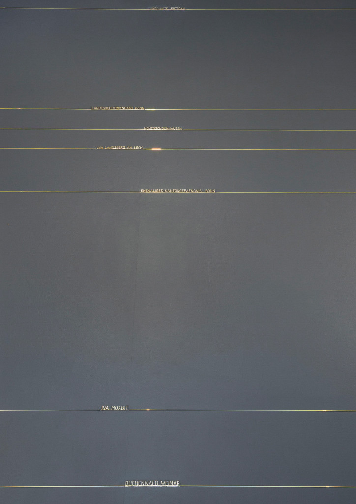 Outlines of prison cells inlayed in a grey platforlm as an art installation