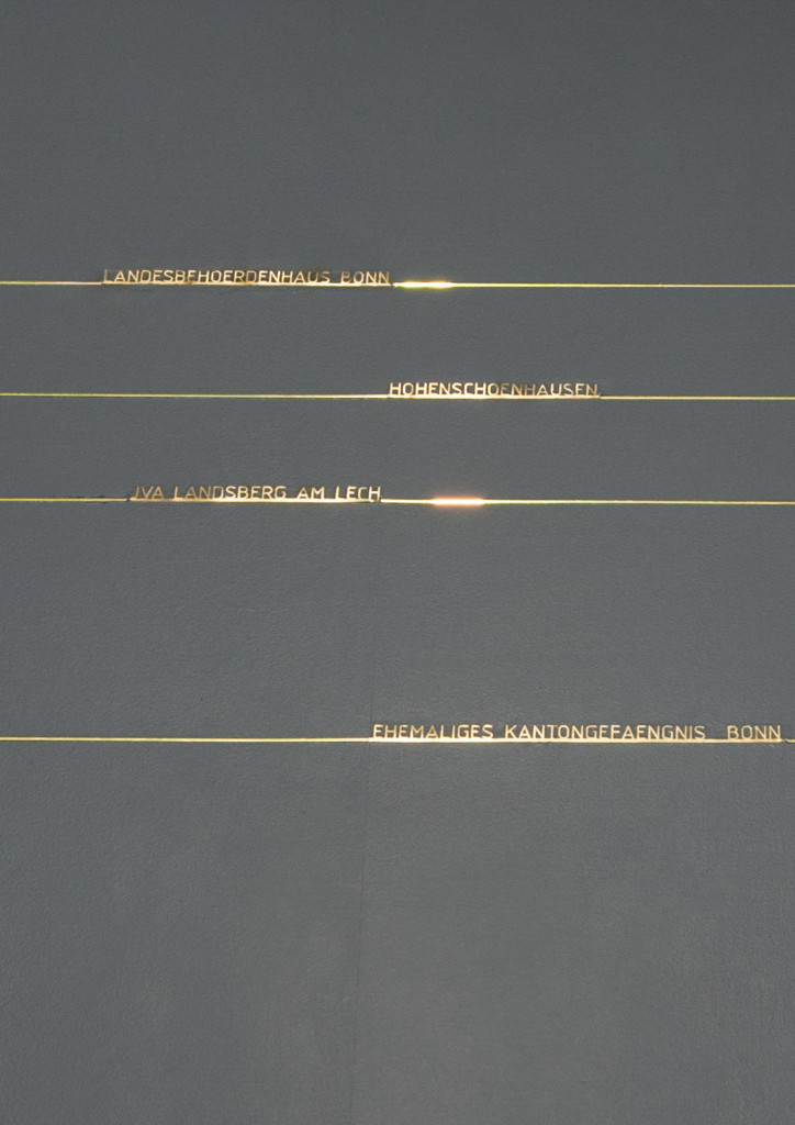 Outlines of prison cells inlayed in a grey platforlm as an art installation