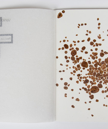 Open artist book with brown specks on the right side. Nadia Kaabi-Linke, Outdoor Reminiscence.