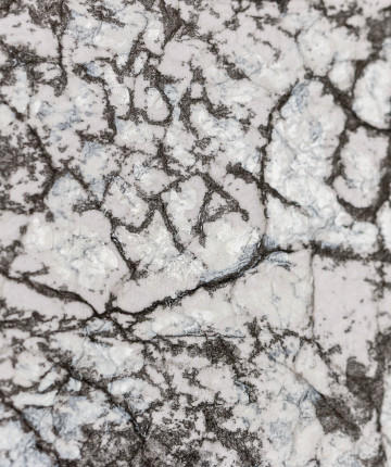 Detail of a canvas surface with a frottage pattern, taken from a wall with cracks and engraved names.