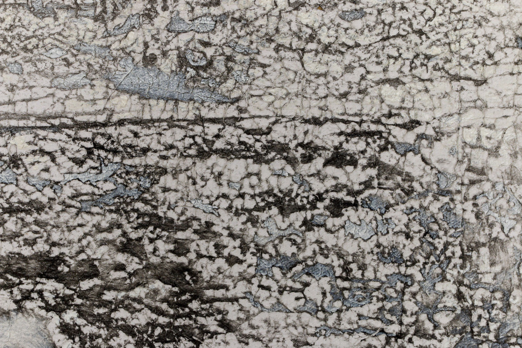 Detail of a canvas surface with a frottage pattern, taken from a wall with cracks and engraved names.