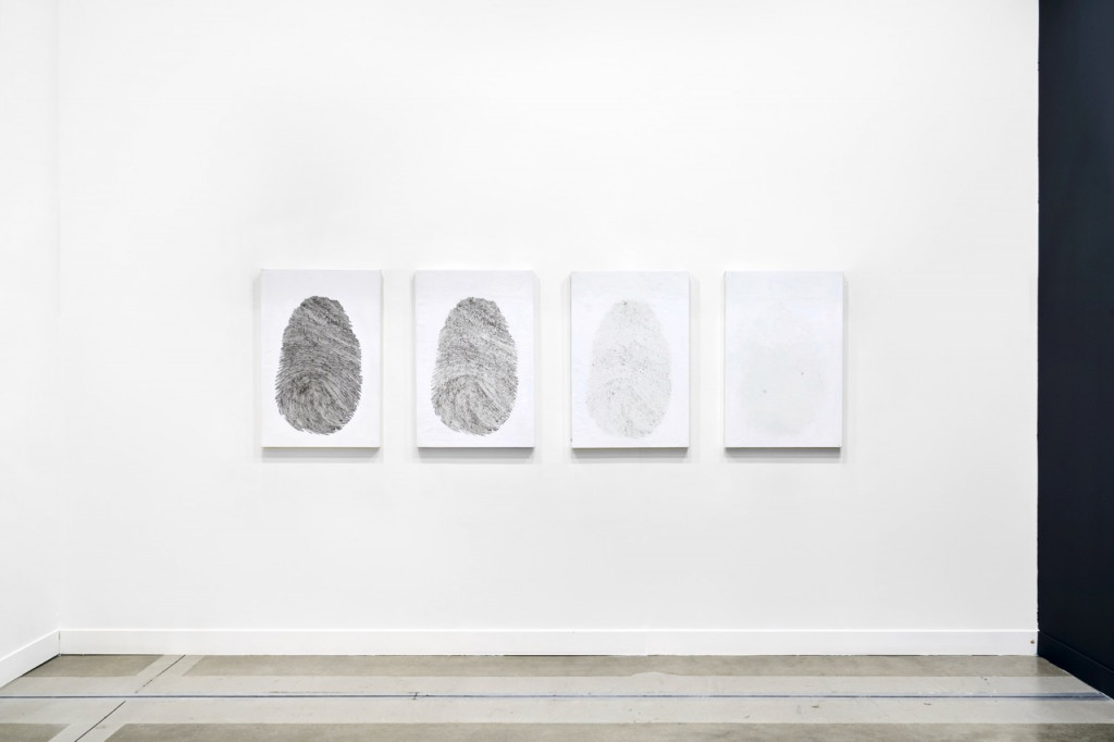 Canvasses with fading fingerprints on a wall