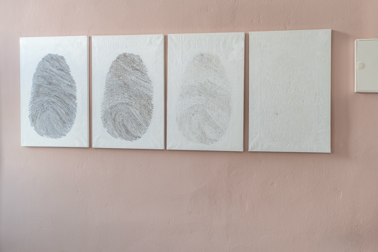 Canvasses with fading fingerprints on a wall