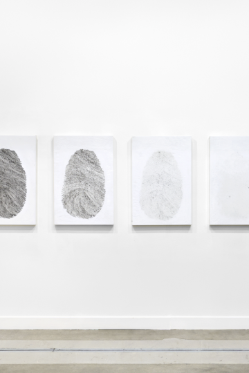 Four framed drawings of finger prints hanging on a white wall. With every image the drawing disappears a little. Vanishing Point, Nadia Kaabi-Linke