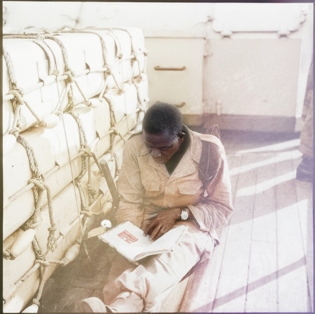 A tirailleur in transit on a boat, reading a book.