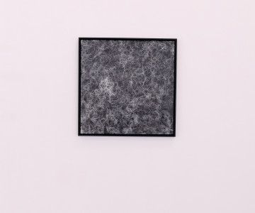 Canvas with titanium white curves on a black ground and with black frames hanging on the wall.